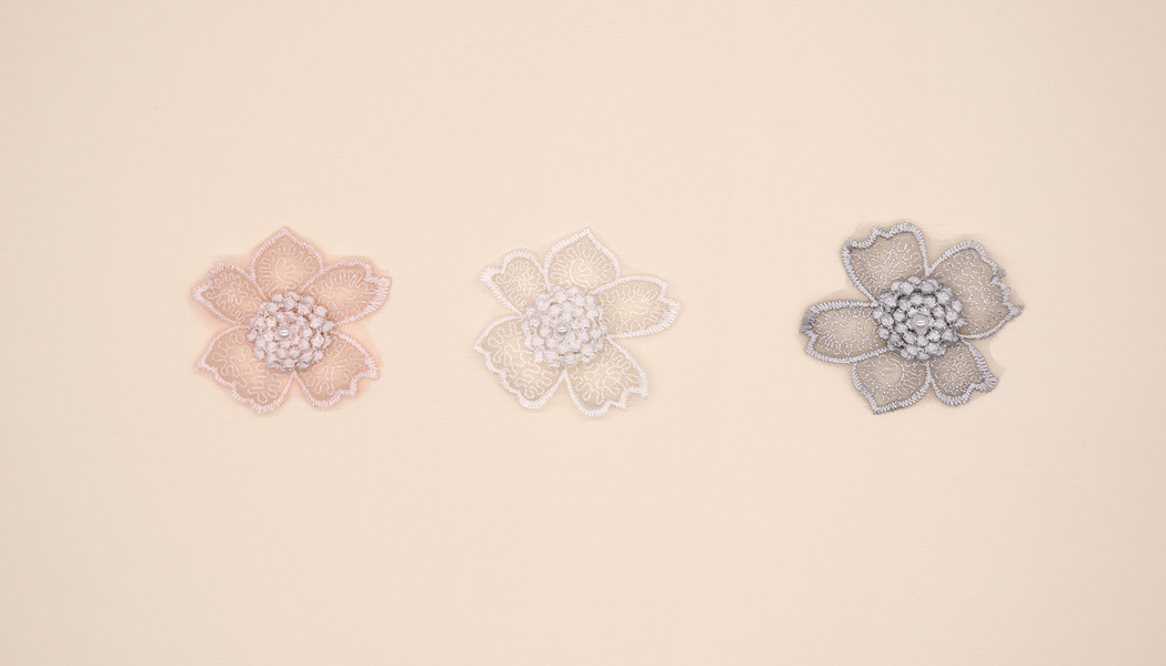 FIORE ASIMMETRICO RICAMATO CON PERLA CENTRALE 