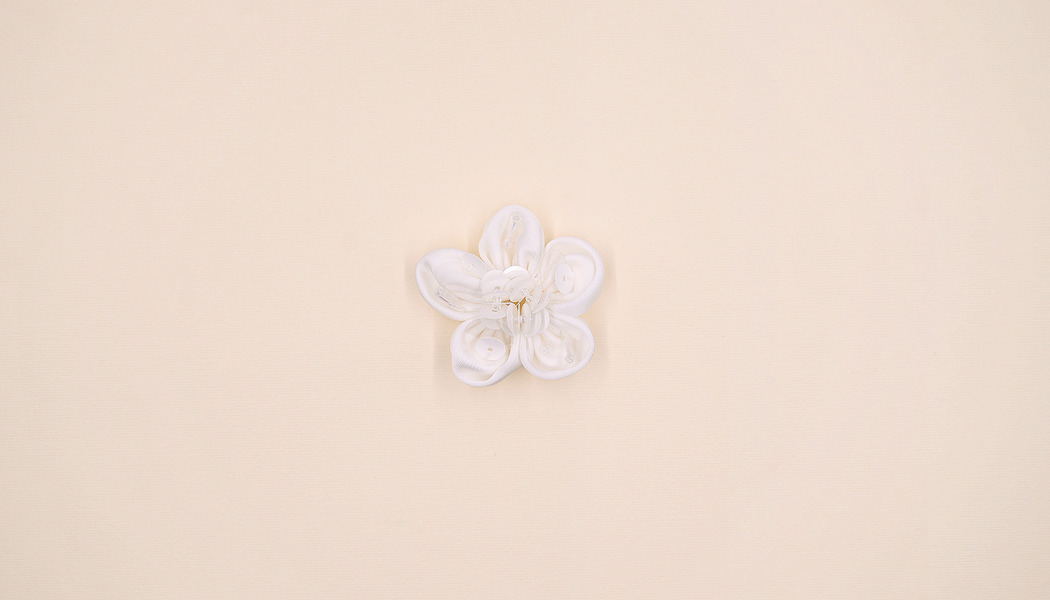 FIORE IN TESSUTO CON RICAMI CENTRALI IN PERLINE E PAILLETTES 